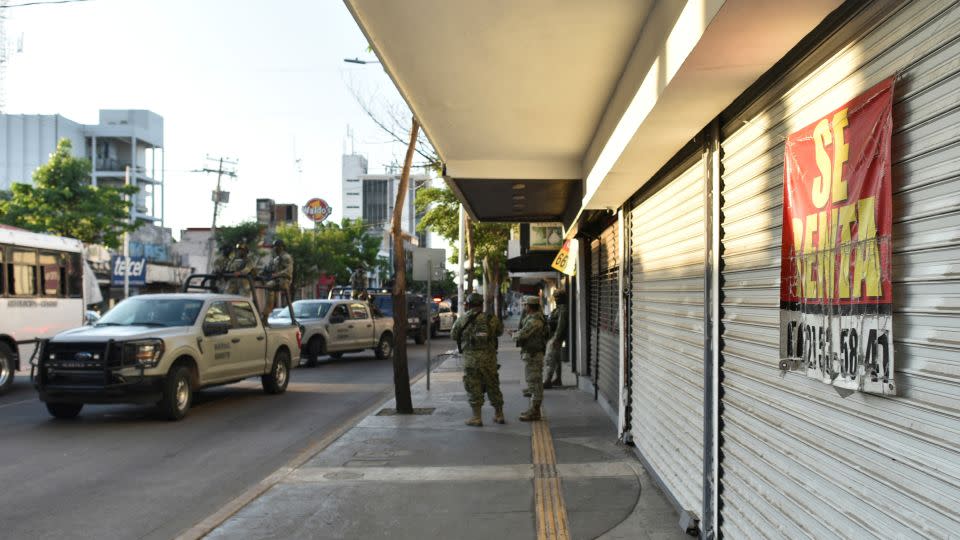 Miembros de las fuerzas federales operan cerca de un negocio cerrado y puesto en renta, mientras la violencia y la crisis económica se intensifican en Culiacán, un año después de la captura del líder del Cártel de Sinaloa, Ismael