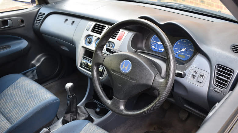 a photo of the 1999 HR-V's dashboard showing its blue seats, dials, and Honda badge