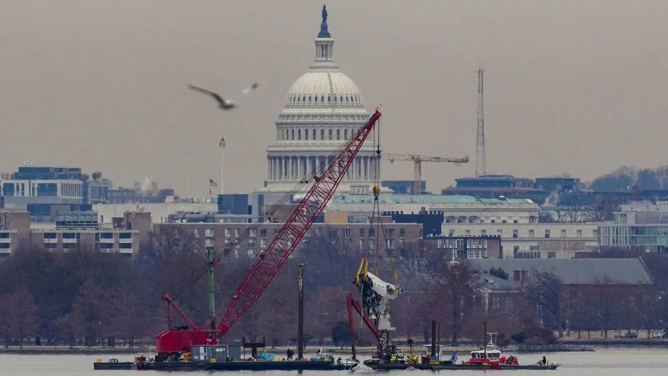A crane retrieves part of the wreckage of American Airlines flight 5342 on February 3, 2025. - Nathan Howard/Reuters