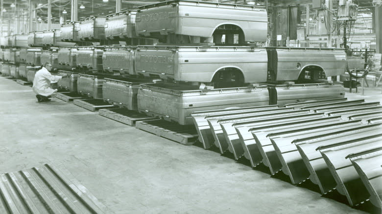 a black and white image of a bunch of vintage Toyota truck beds inside the Long Beach facility