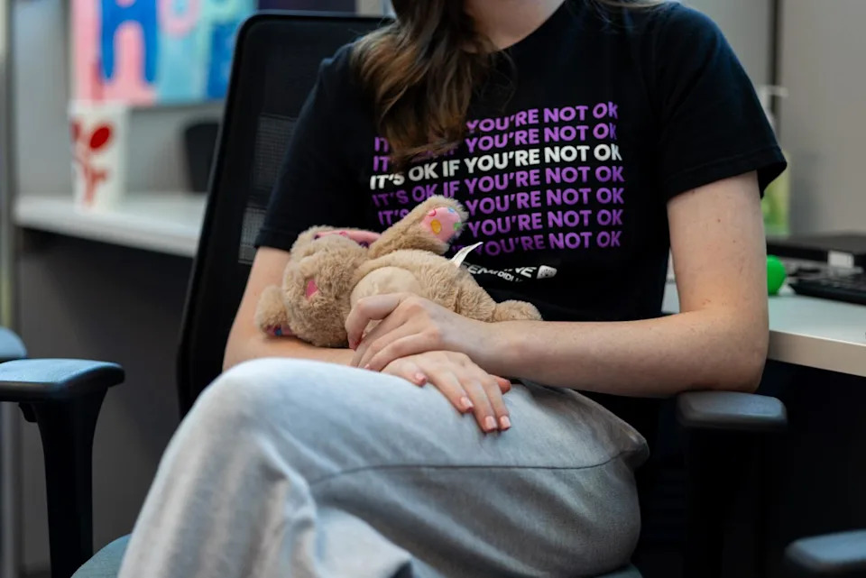 Teen Line volunteer Sydney, 17, holds one of the "emotional support" stuffed animals decorating the office.