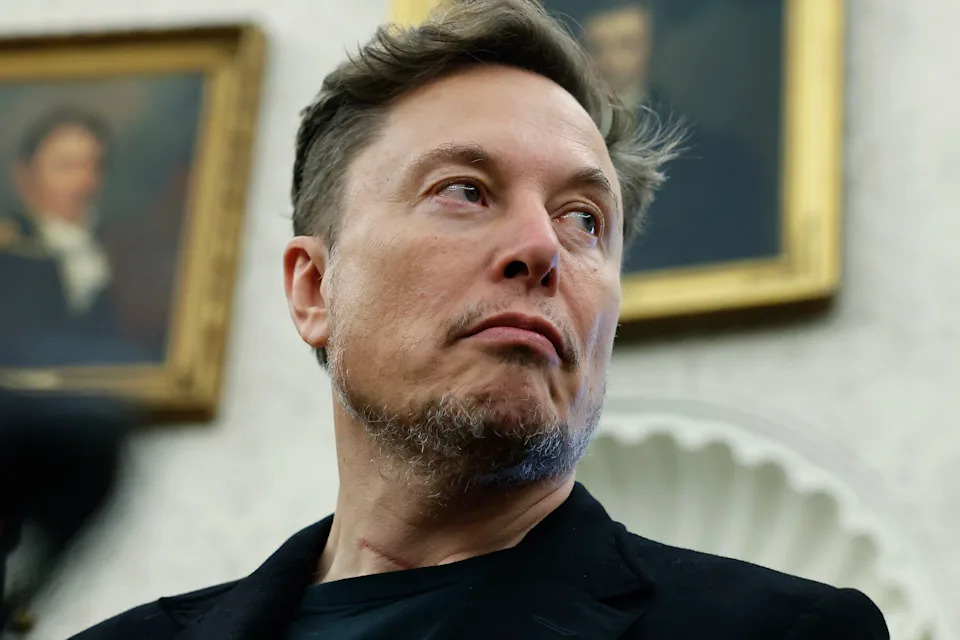 Elon Musk looks toward his right in the Oval Office at the White House.